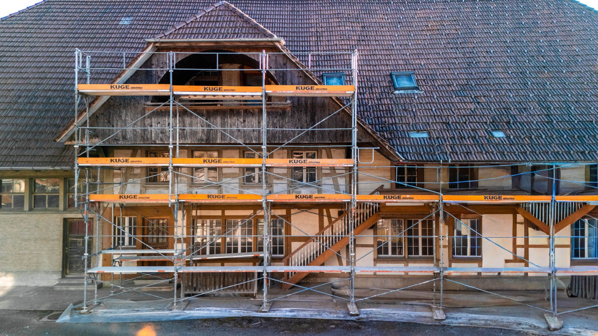 Gerüstbau montiertes Fassadengerüst mit Netzbespannung – Foto: KUGE Bau AG