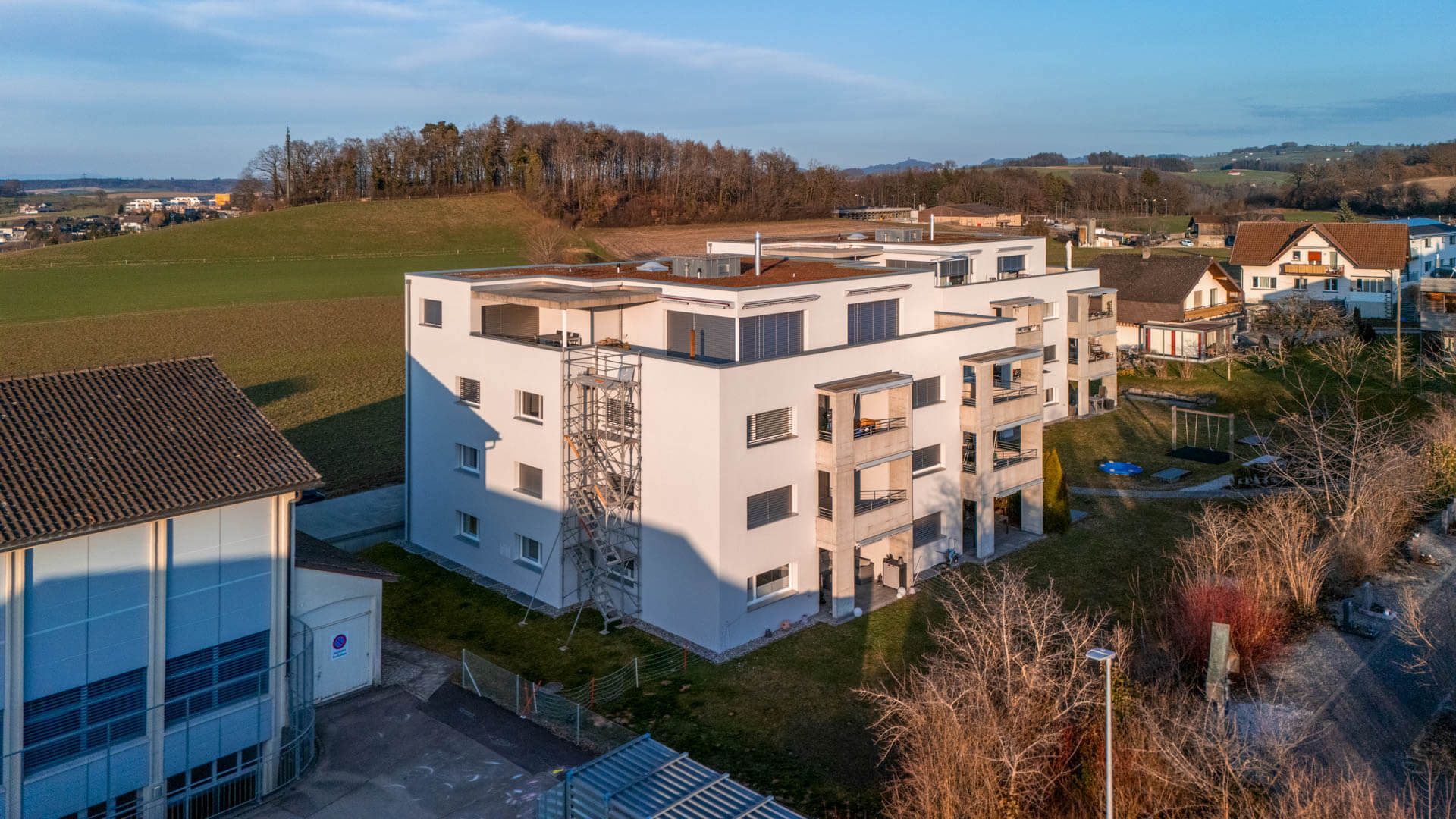 Gerüst mit Treppenaufstieg an einem viergeschossigen Mehrfamilienhaus – Foto: KUGE Bau AG